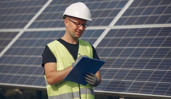 man-with-white-helmet-near-solar-panel