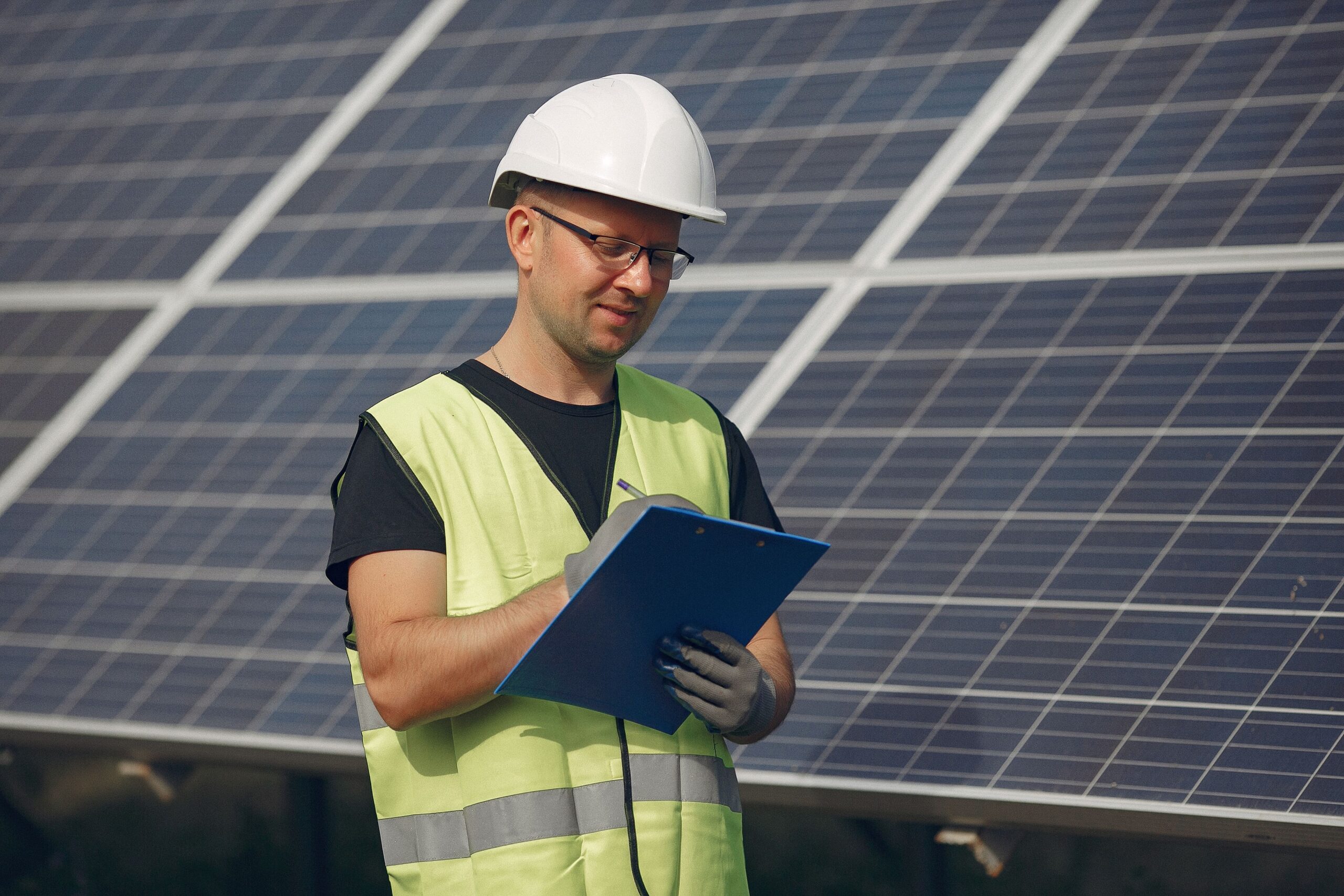 man-with-white-helmet-near-solar-panel